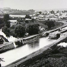 A view of the Erie Canal with its waterway and surrounding landscape.