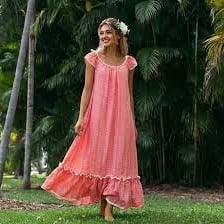 A person wearing a flower lei with a Hawaiian dress.