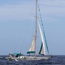 A sailboat moving with the wind behind it.