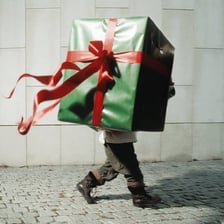 A person handing another person a wrapped gift.