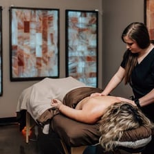 A person reclining in a spa setting with an expression of relaxation.