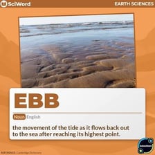 Seawater receding from a shoreline as the tide ebbs