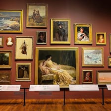 A museum gallery displaying paintings and sculptures.