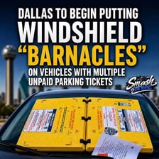 A vehicle windshield displaying parking tickets.