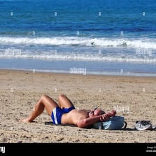 A person relaxing in sunlight while sunbathing.