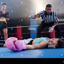 A boxing referee counting over a fallen boxer