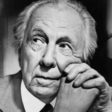 A portrait of Frank Lloyd Wright beside one of his buildings