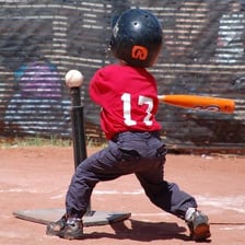 Children batting a baseball from a tee