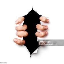 Hands ripping a sheet of paper apart