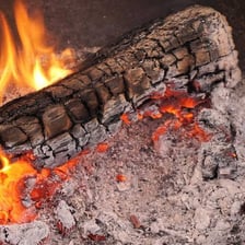 A small wood fire with gray ash visible beneath the flames.