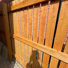 Open spaces between fence boards.