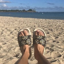 A pair of sandals on a beach.