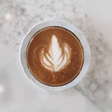 A latte in a coffee cup representing a half-caf order