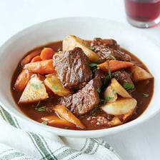 A pot of stew containing vegetables and pieces of meat.