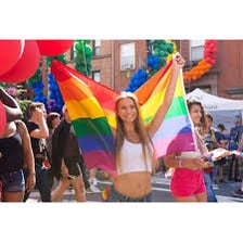 A Pride parade with rainbow flags and LGBT participants.