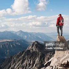 A person climbing upward on a mountain trail.