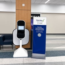 Travelers moving through an airport security checkpoint marked for TSA PreCheck.
