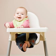 Babies seated in high chairs at a table