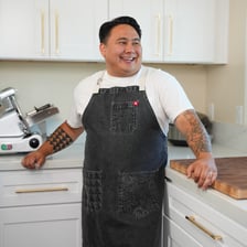 A cook wearing an apron while preparing food