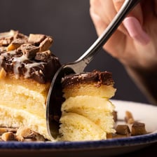A sliced Boston cream pie showing its cream filling and chocolate topping