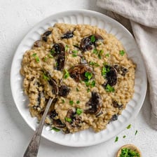 Arborio rice grains and a bowl of creamy risotto