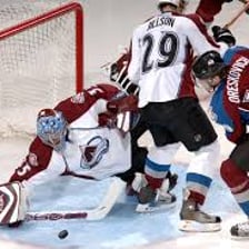 A hockey goalie blocking a shot