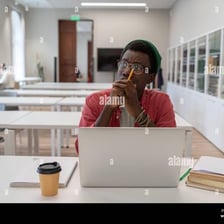 A student with glasses studying at a desk.