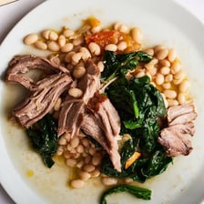A serving of pork and beans in a bowl.