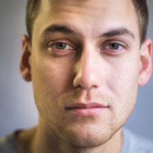 A portrait showing a pale, tired-looking face
