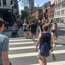A pedestrian walking along an unremarkable everyday street.