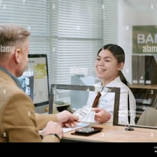 A cashier serving a customer at a bank counter