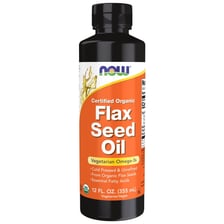 Flax seeds beside a bottle of linseed oil