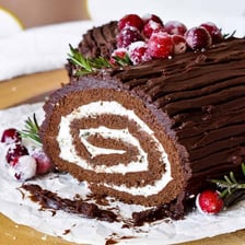A log-shaped Yule log cake decorated for Christmas.