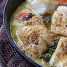 A bowl of thin porridge beside a ling fish