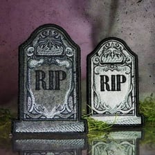 A cemetery tombstone bearing the letters RIP.