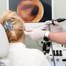 A clinician examining a patient's ear, nose and throat.