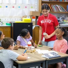 A trainee student working at a desk in a classroom