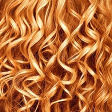 A close-up photograph of hair styled in a perm