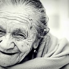 An elderly woman smiling in portrait view.
