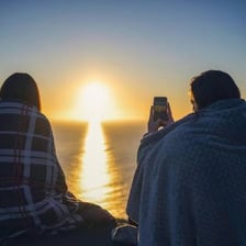 A person relaxing outdoors at sunset.