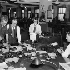 Journalists working in a busy newsroom