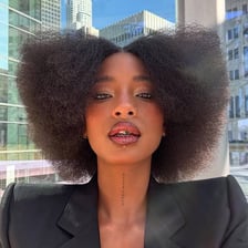 A person shown wearing a rounded afro hairstyle.
