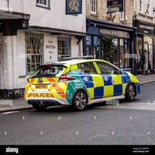 A marked British police car on a street