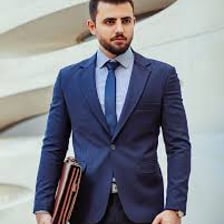 A person wearing a neatly fitted formal suit.