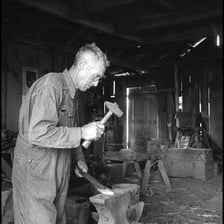 A person repeatedly striking metal with a hammer