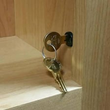 A hand securing a door with a lock.