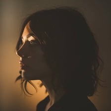 A shadowy portrait of a dark-haired person.