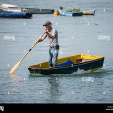 A person aboard a boat holding an oar