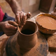 A potter shaping clay on a pottery wheel