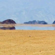 A desert scene showing a mirage that resembles distant water